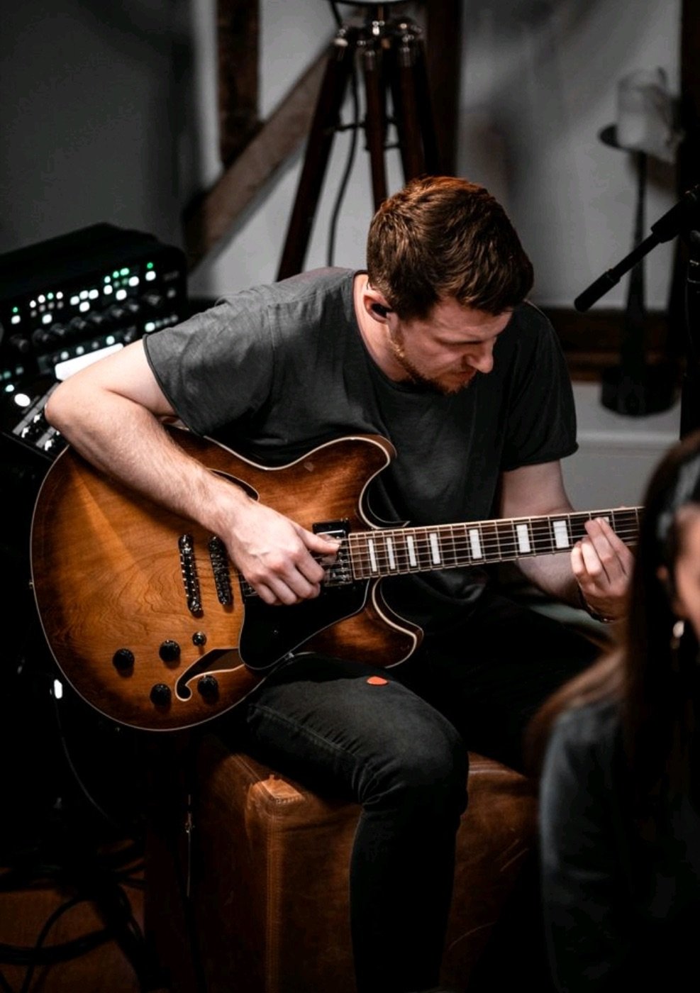 David Niskin recording electric guitar beside studio equipment.