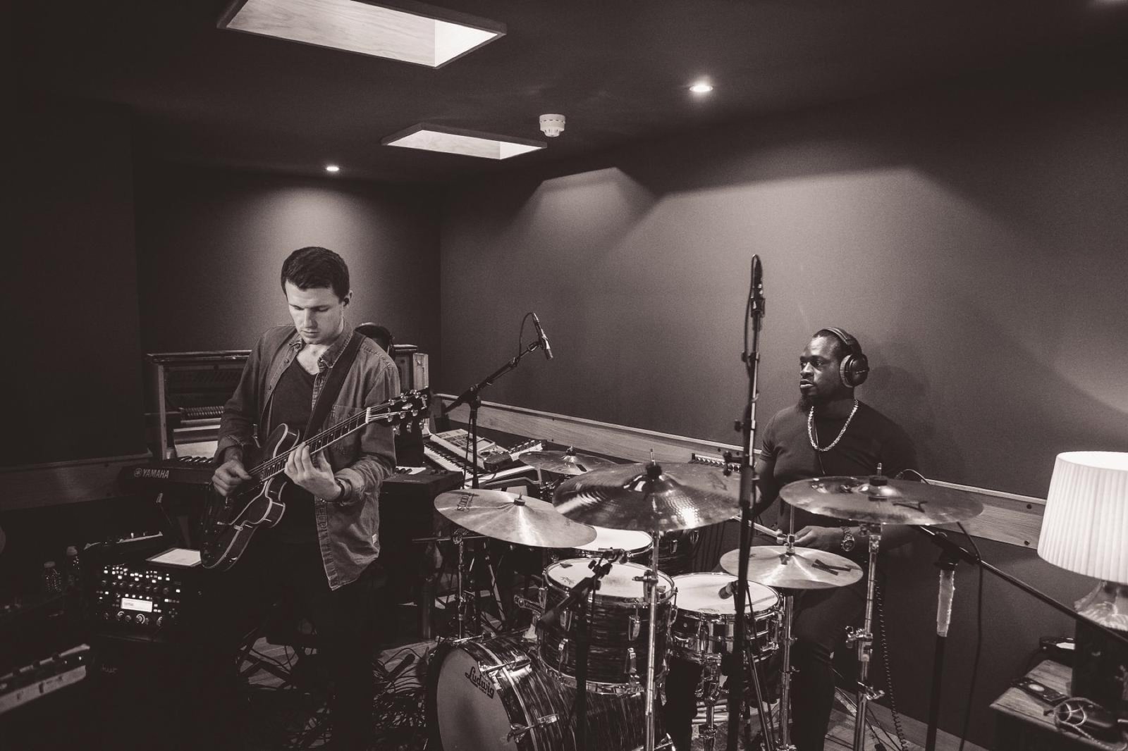 David Niskin recording electric guitar with a drummer in a professional studio.